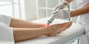 A doctor performs laser therapy for foot neuropathy on a patient's foot.